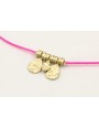 Pulsera hilo fucsia con colgantes laminas labradas