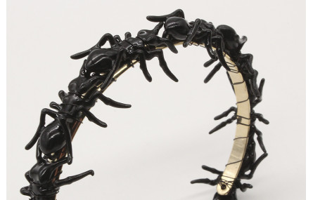 Pulsera rígida con hormigas negras.