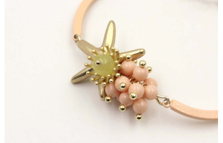 Pulsera semirigida con bolas rositas, estrella oro