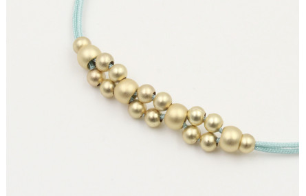 Pulsera hilo macrame menta con  bolas en oro mate.